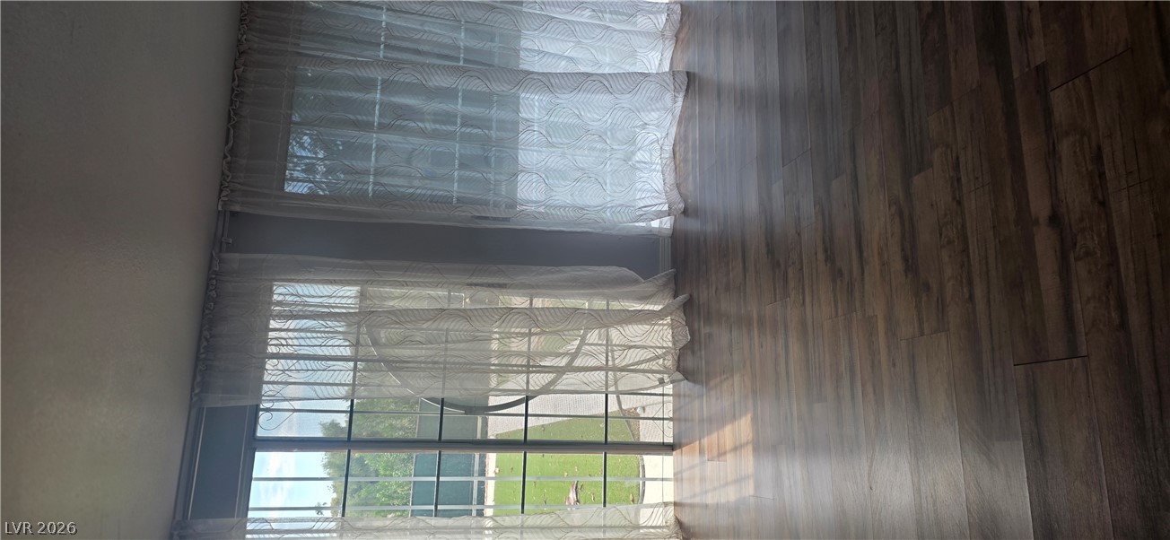 Rich wood flooring anchors this sunlit interior framed by sliding glass doors.