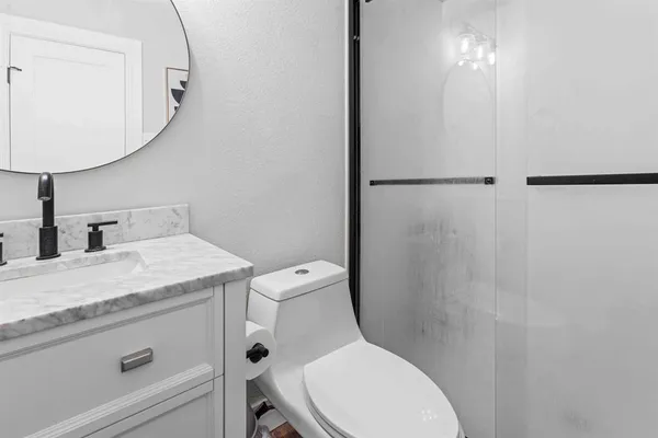 a bathroom with a granite countertop toilet sink and mirror