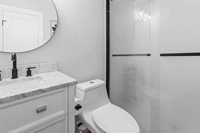 a bathroom with a granite countertop toilet sink and mirror