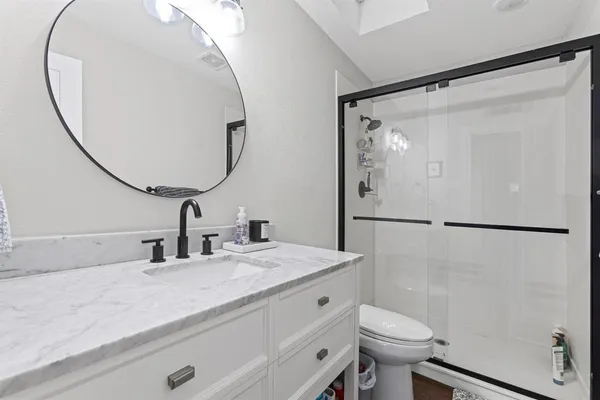 a bathroom with a sink mirror toilet and vanity