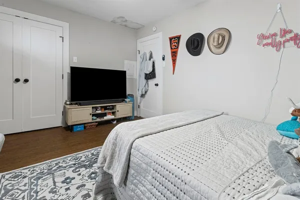 a bedroom with a bed and a flat screen tv