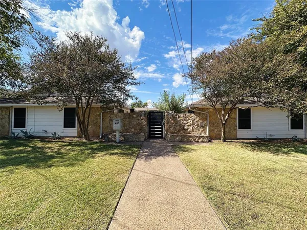 a view of a house with a patio and a yard