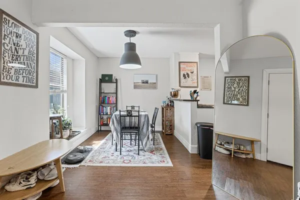a living room with furniture and a dining table with wooden floor