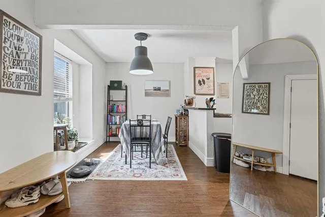 a living room with furniture and a dining table with wooden floor