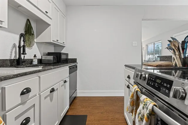 a kitchen with granite countertop a stove and a sink