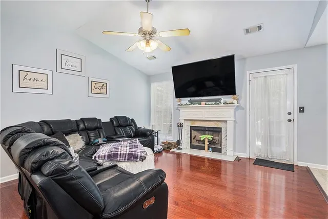 a living room with furniture a fireplace and flat screen tv