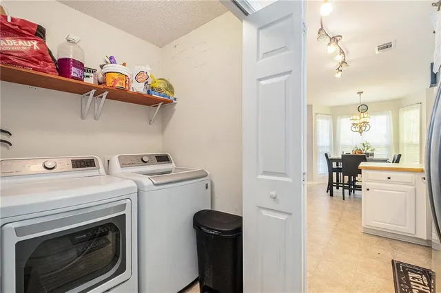 a view of washer and dryer with kitchen in the background
