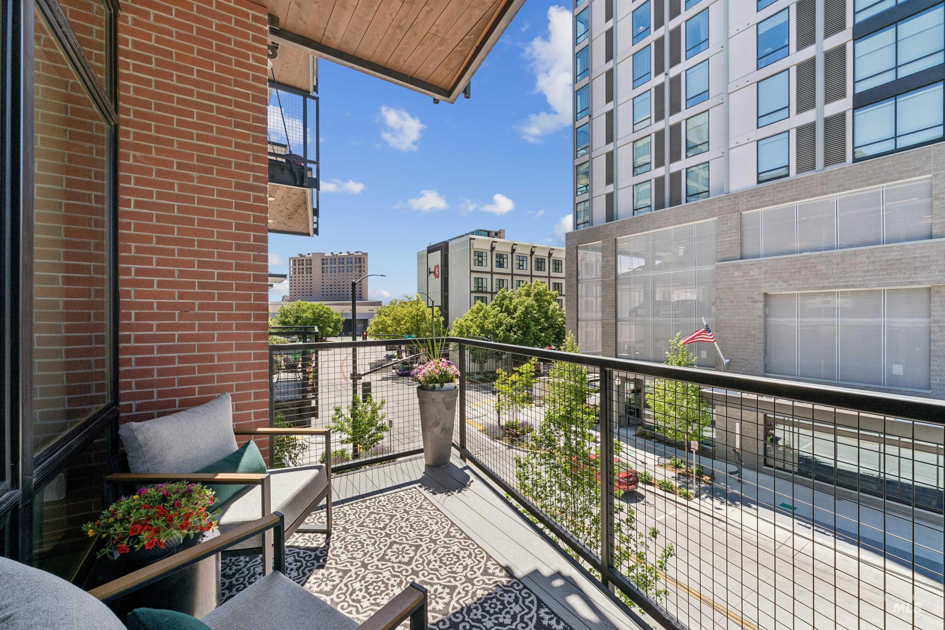 119 South 10th Street, Unit 307 Boise, ID 83702 - Photo 11 of 47 Private balcony featuring a wood plank ceiling, brick facade, and metal railing