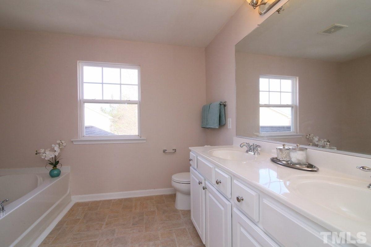 832 Seastone Street Raleigh, NC 27603 - Photo 16 of 25 a bathroom with a tub sink toilet and mirror