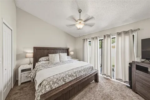 a bedroom with a large bed and a flat tv screen on dresser