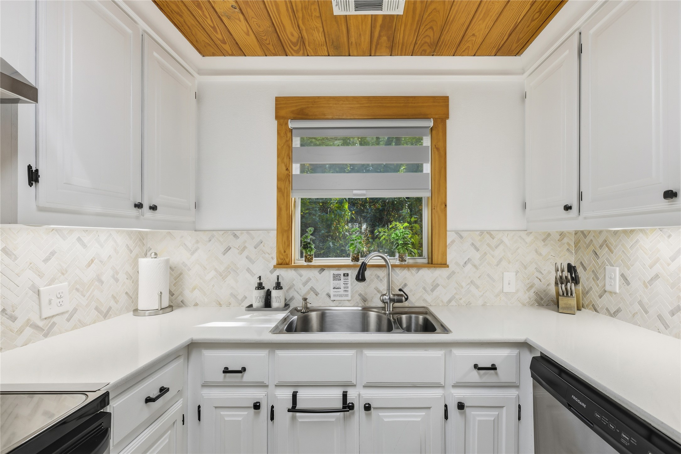 10716 Beach Road Leander, TX 78641 - Photo 35 of 39 Kitchen featuring light countertops, dishwasher, white cabinets, wooden ceiling, and backsplash