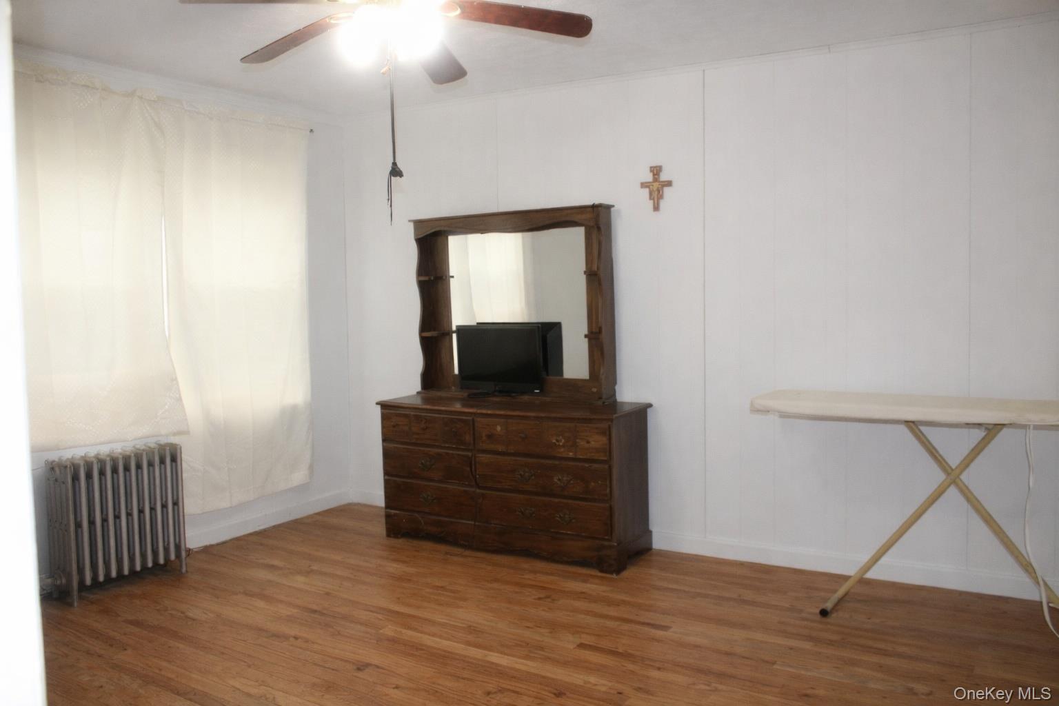 131-16 226th Street Queens, NY 11413 - Photo 8 of 12 a room with a bed and a flat screen tv