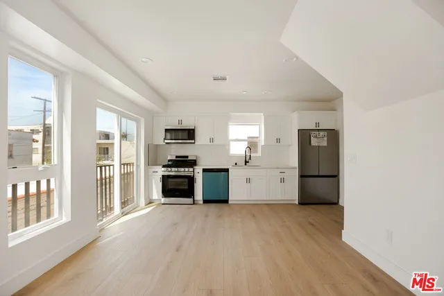 a kitchen with stainless steel appliances a refrigerator and a stove top oven