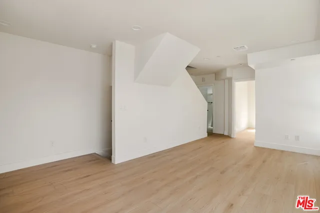a view of a room with wooden floor and white walls