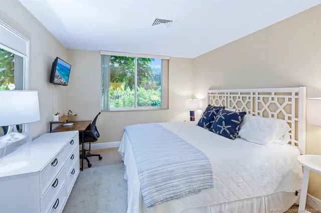 a spacious bedroom with a bed and a lamp