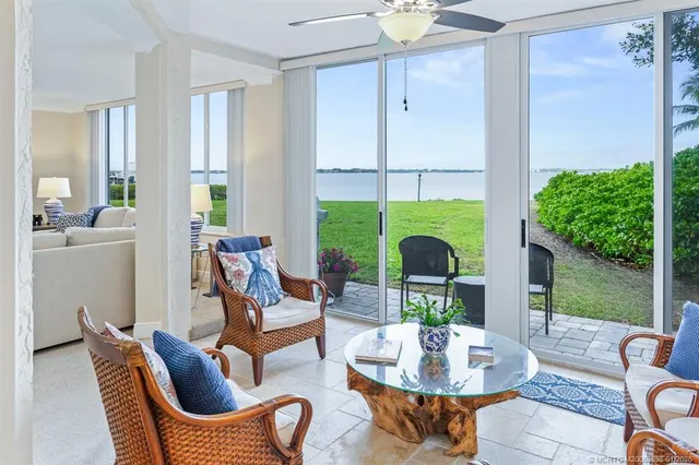 a living room with furniture a large window and a chandelier