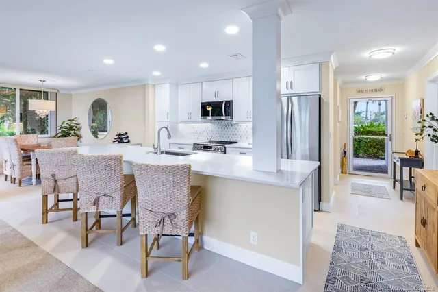 a kitchen with a dining table chairs and refrigerator