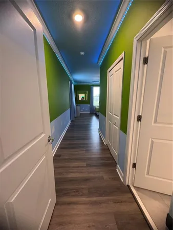 a view of a hallway with wooden floor and stairs