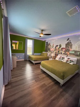 a bedroom with a large bed and a wooden floor