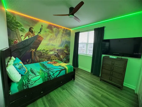 a living room with a bed and a television