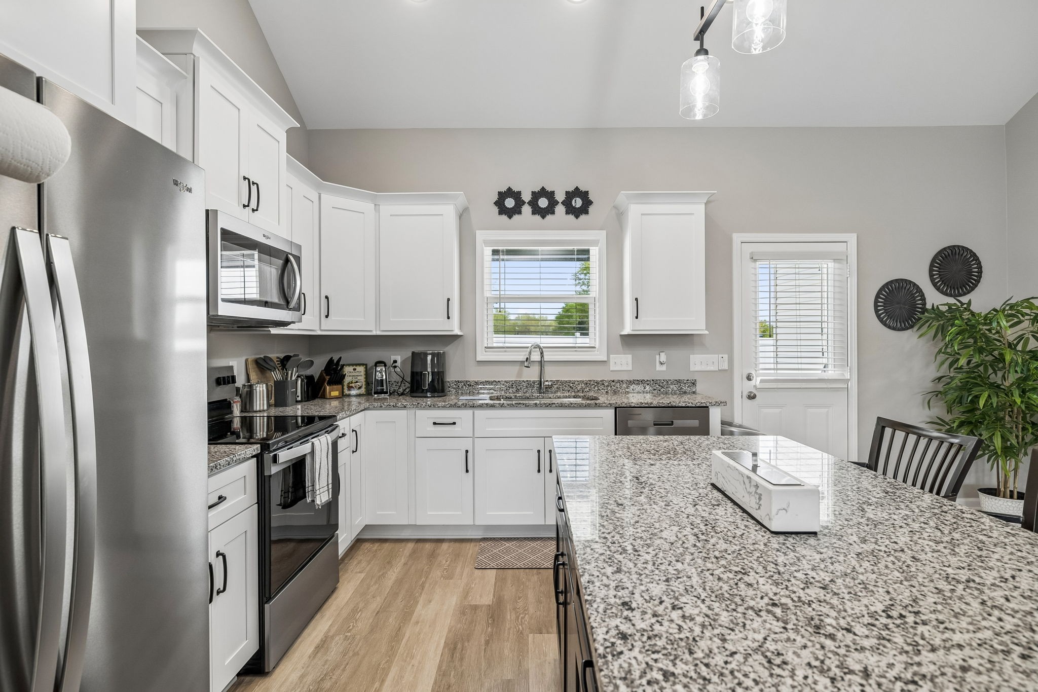 180 Vickers Hill Road Smithville, TN 37166 - Photo 12 of 33 a kitchen with stainless steel appliances granite countertop a refrigerator a stove top oven a sink a dining table and chairs with wooden floor