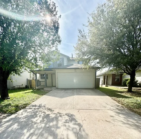a view of a house with a yard and large trees