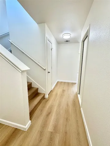 a view of a hallway with wooden floor