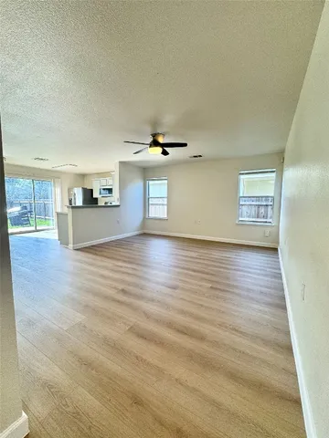 a view of an empty room with wooden floor