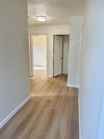 a view of an empty room with wooden floor