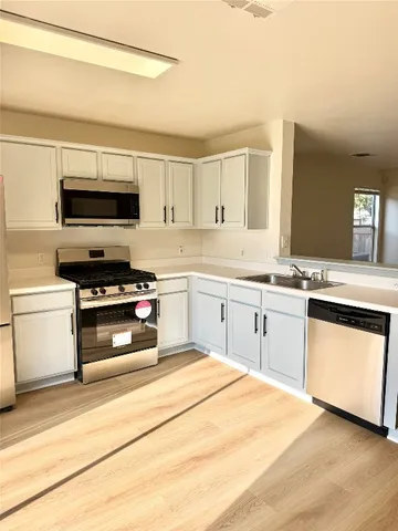 a kitchen with a stove white cabinets and a sink