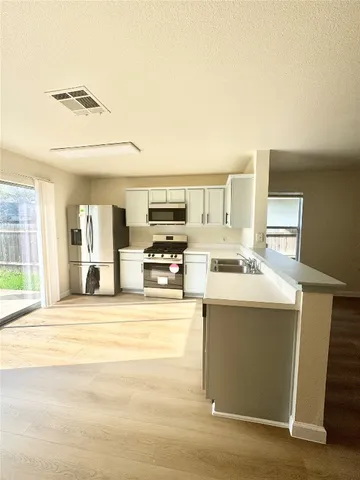 a view of kitchen with sink microwave and refrigerator