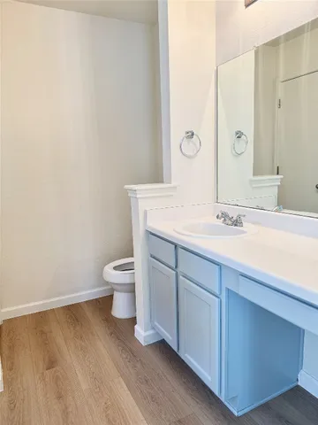 a bathroom with a granite countertop sink a toilet and a mirror