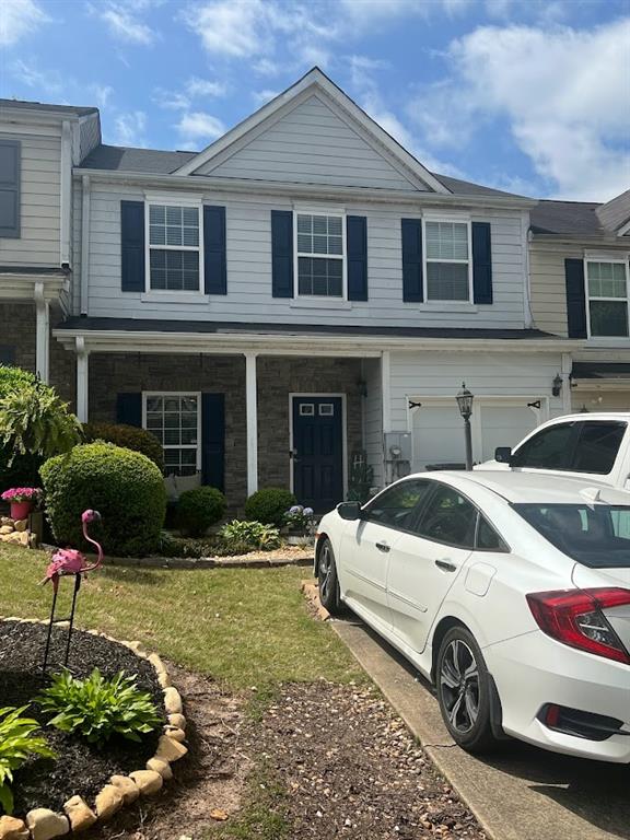 a front view of a house with a garden and plants