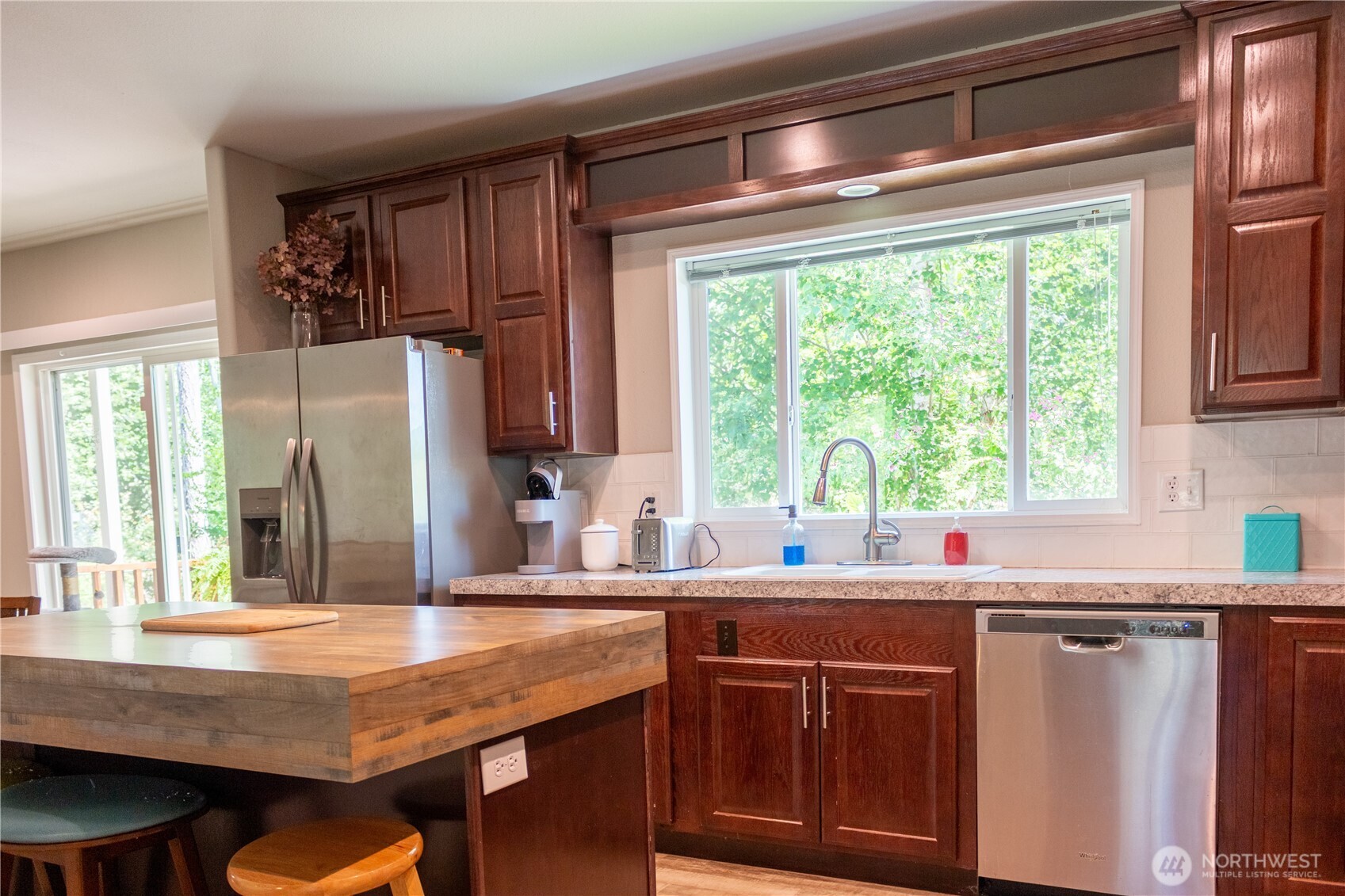 3111 East Rasor Road Belfair, WA 98528 - Photo 7 of 26 a kitchen with stainless steel appliances granite countertop a sink and a refrigerator