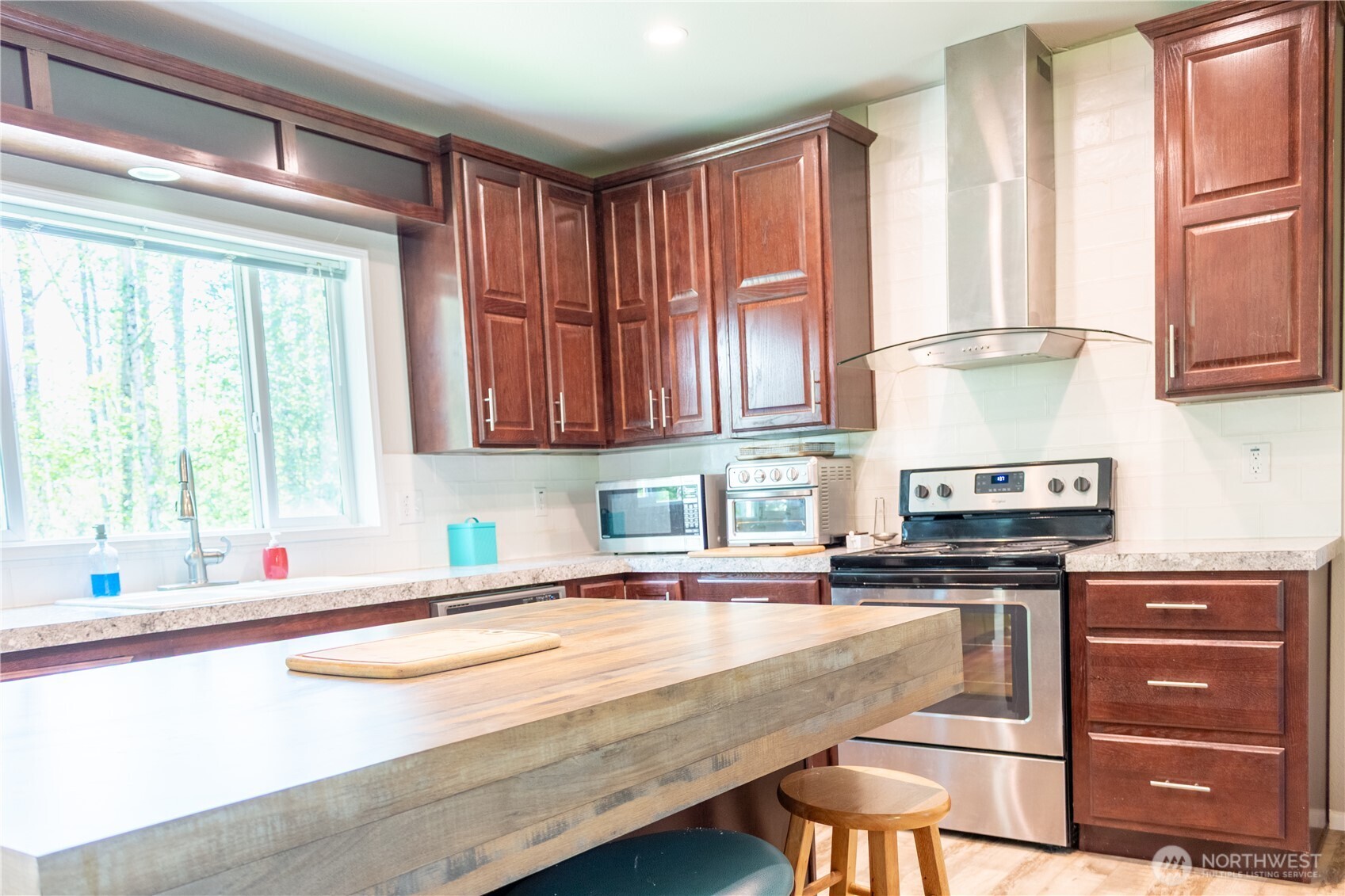 3111 East Rasor Road Belfair, WA 98528 - Photo 8 of 26 a kitchen with stainless steel appliances granite countertop a sink a stove and a microwave