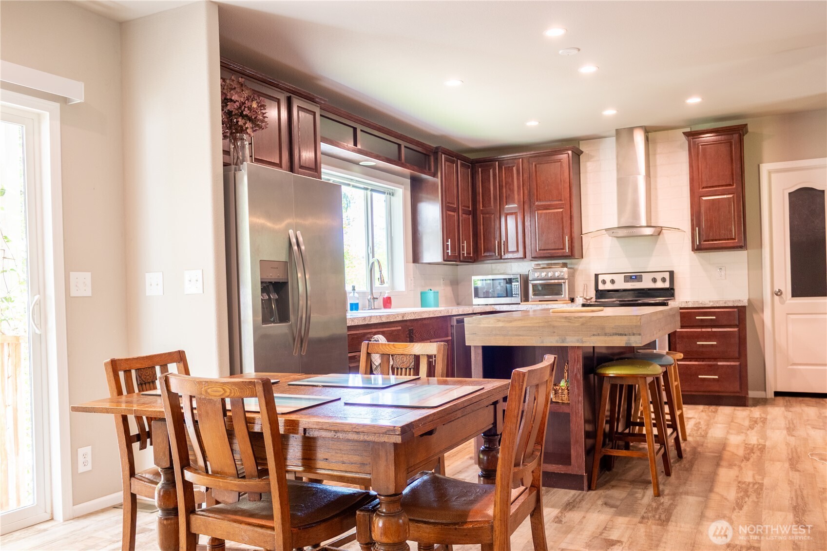 3111 East Rasor Road Belfair, WA 98528 - Photo 9 of 26 a kitchen with a table chairs refrigerator and cabinets