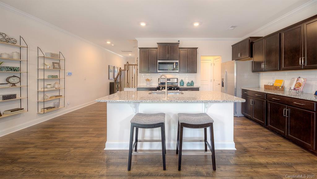 313 Bulrush Rd Lake Lake Wylie, SC 29710 - Photo 12 of 39 a kitchen with stainless steel appliances granite countertop a sink a stove a refrigerator cabinets and chairs