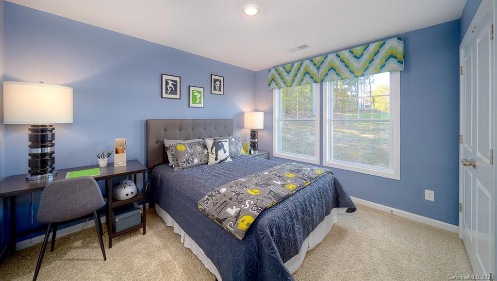 313 Bulrush Rd Lake Lake Wylie, SC 29710 - Photo 26 of 39 a bedroom with a bed and a lamp on table