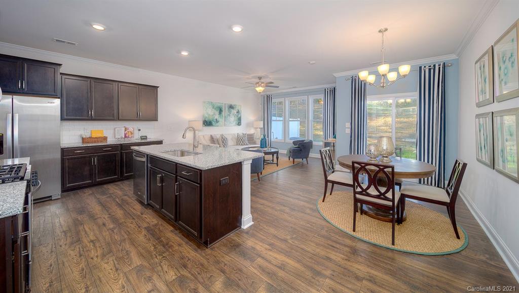 313 Bulrush Rd Lake Lake Wylie, SC 29710 - Photo 10 of 39 a kitchen with stainless steel appliances granite countertop a stove a sink dishwasher a microwave oven and a dining table with wooden floor