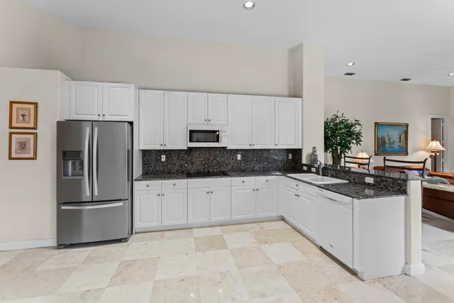 a kitchen with stainless steel appliances granite countertop a refrigerator sink and stove