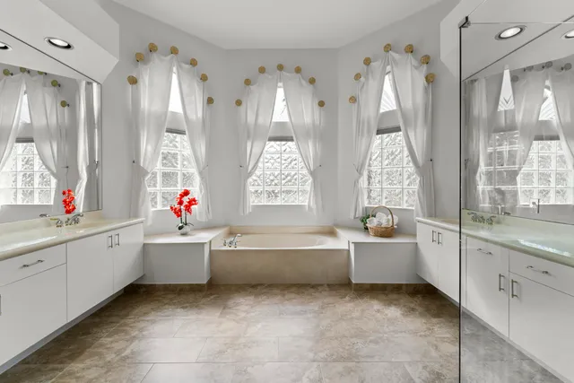 a bathroom with a tub sink and mirror