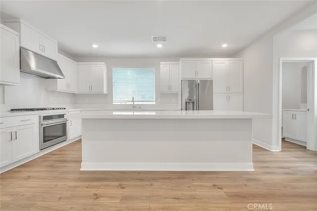 an empty room with wooden floor and window