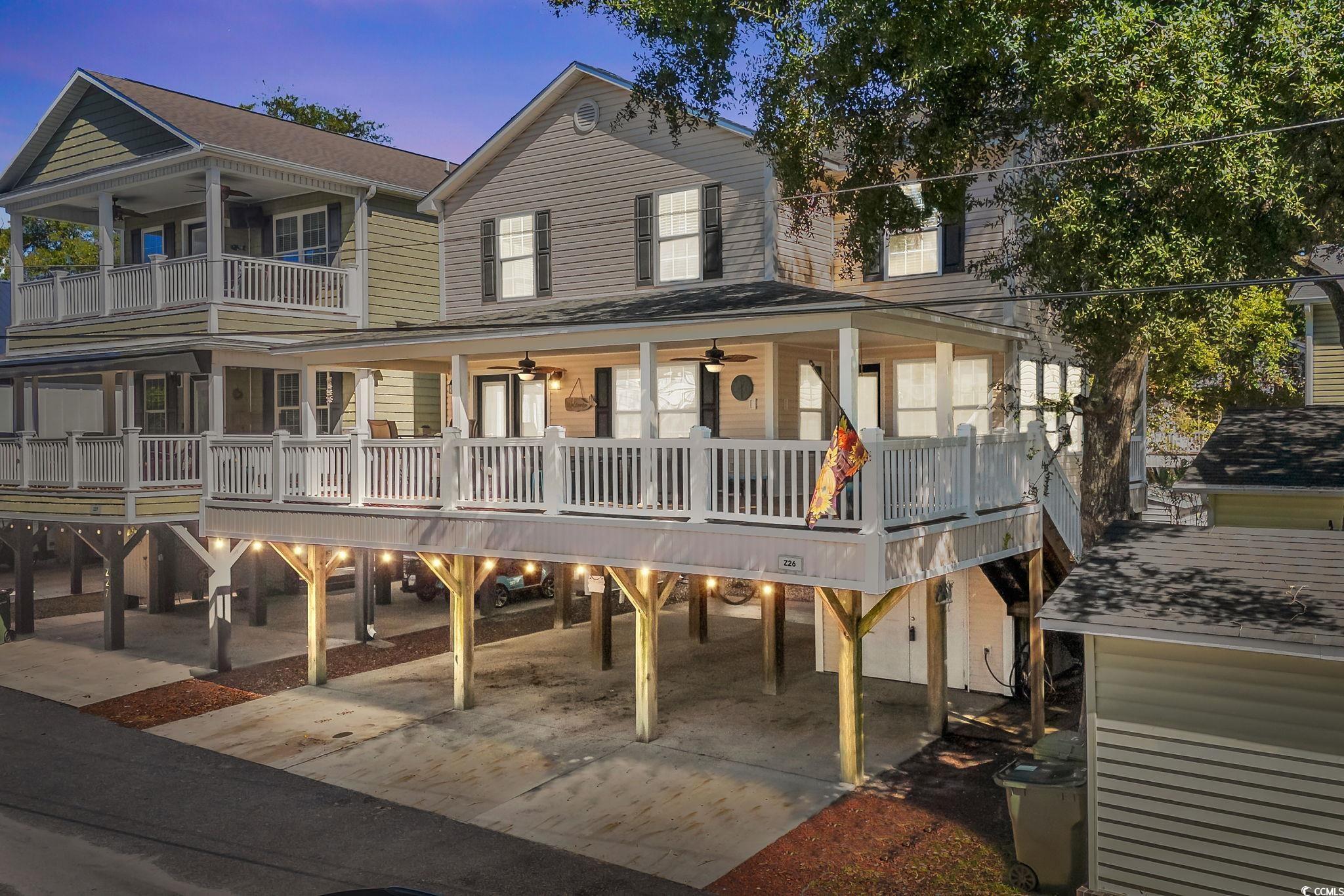 View of front of home with ceiling fan, a large porch, and a carport