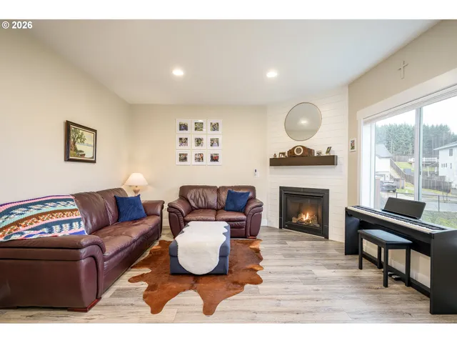 a living room with furniture a fireplace and a large window