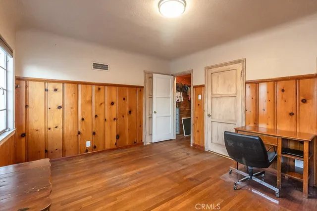 a view of a room with wooden floor and furniture