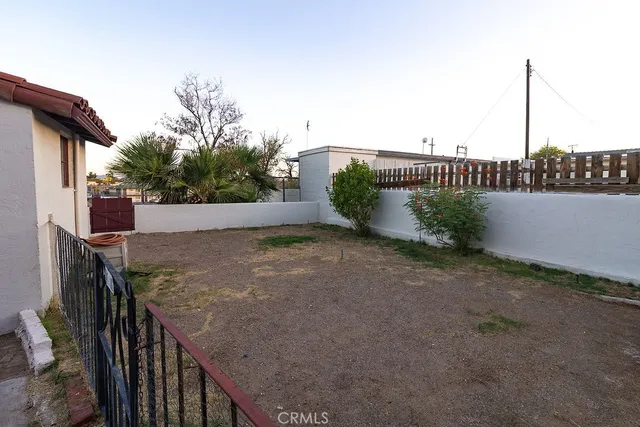 a view of a dry yard with trees