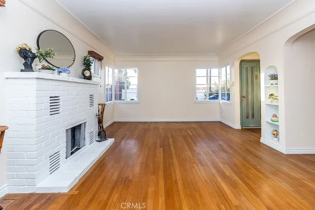 a living room with a fireplace and wooden floor