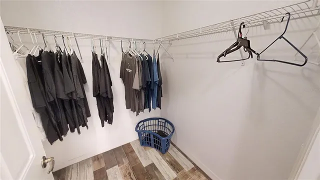 a view of walk in closet with clothes and shoes