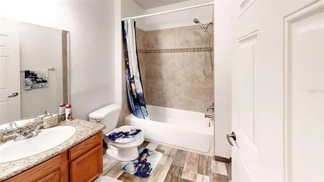 a bathroom with a granite countertop sink mirror toilet and bathtub