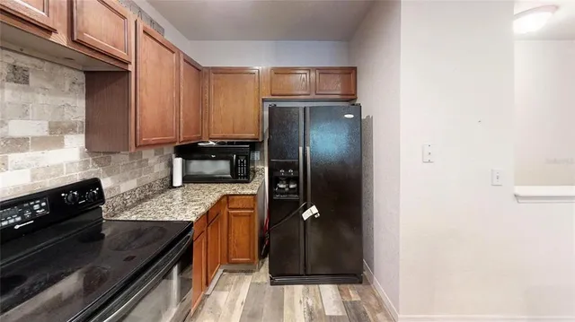 a kitchen with granite countertop a refrigerator and a stove